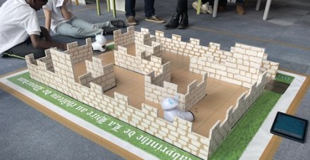 Le robot Photon circule dans son chateau fort grâce à des élèves qui le programment.